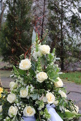 Gesteck mit weißen Rosen auf dem Friedhof nach Beerdigung