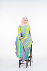 Beautiful female model wearing a pastel batik kaftan/caftan, a traditional dress for Muslim women isolated over white background. Stylish Muslim female hijab fashion lifestyle portraiture concept.