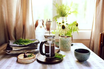 summer morning at wooden cottage kitchen with coffee and wild ferns in vase