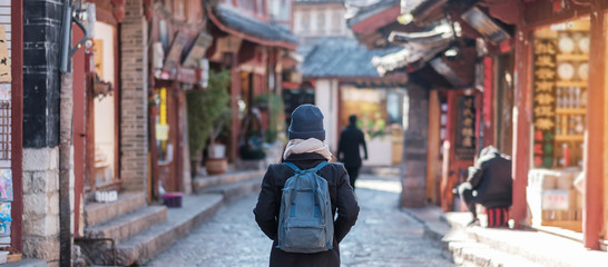 young woman traveler traveling at the Square street in Lijiang Old Town, landmark and popular spot...