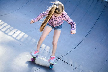 teenage girl, trains, on skateboard, in skatepark