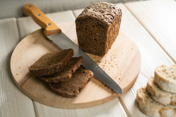 Sliced rye bread on cutting board. Whole grain rye bread with seeds