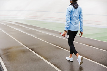 Attractive young african sportswoman resting after running