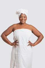 Portrait of woman with body and head wrapped in towels over white background