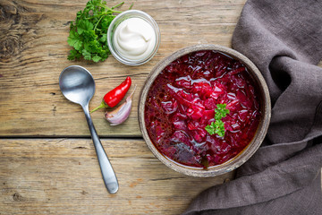 Traditional Ukrainian Russian vegetable beet soup, borscht on wooden background, top view