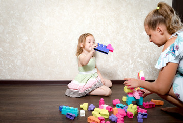 Naklejka premium Mom and daughter play constructor