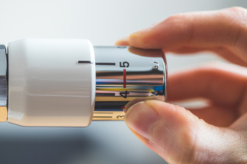 Indoor climate: Heat regulator on a heater, close up picture. Set On, heating costs.