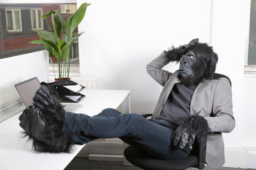 Thoughtful young man in gorilla costume resting at office © MDBPIXS