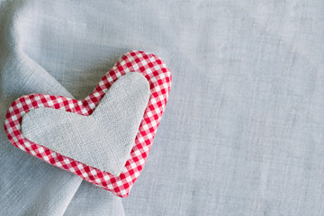 Valentine's day and mother's day celebration template. Handmade heart made of canvas and checkered fabric on a linen background