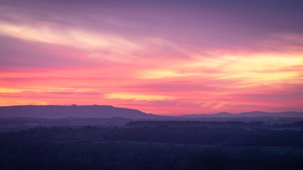 Fototapeta na wymiar A colourful winter sunset over the Avon valley with the Cotswold escarpment in the distance.