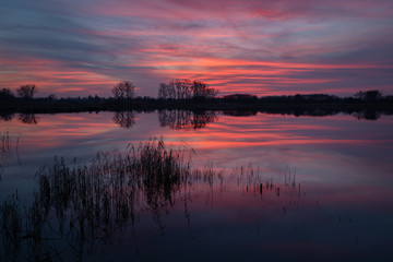 Obraz premium The reflection of colorful clouds in the water after sunset in Stankow, Poland