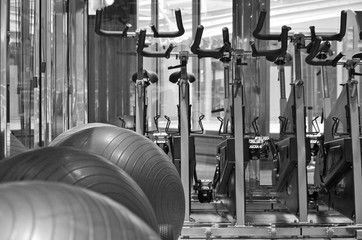 Staying fit with cardio fitness equipment like spinning bikes and medicine balls in gym or fitness...