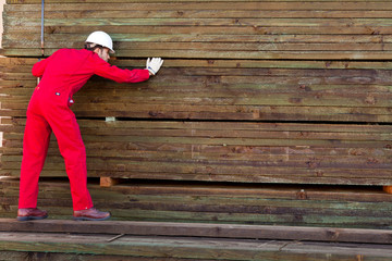 Hispanic worker inspecting timber wooden planks