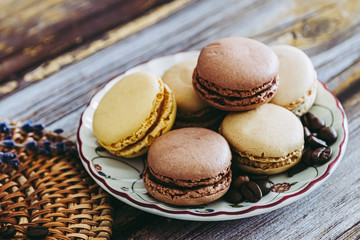 Macarons praline vanille café chocolat sur une coupelle en céramique