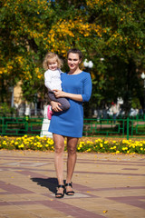 Obraz premium Closeup portrait of a young beautiful mother with little curly daughter in autumn park