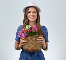 beautiful woman in hat holding hand bag with flowers.