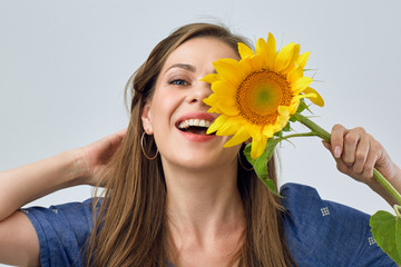 woman holding sunflower in front of face.
