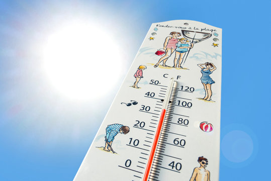 Worm's-eye view of thermometer measures extremely hot temperature of 32 degrees Celsius / 32 °C / 90 °F during heatwave / heat wave in summer