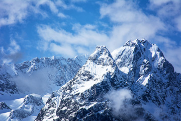Snowy mountain peaks and sky with clouds