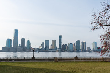 Fototapeta na wymiar Empty Waterfront at Battery Park in New York City with a view of the Jersey City Skyline along the Hudson River