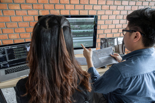Two professional programmer cooperating and working on web site project in a software developing on desktop computer at company, codes and typing data code, Programming with HTML, PHP and javascript