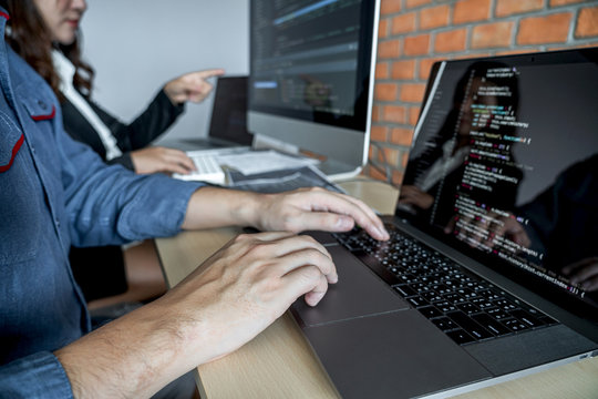 Programmers cooperating at Developing programming and website working in a software develop company office, writing codes and typing data code, Programming with HTML, PHP and javascript