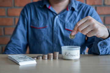 Fototapeta na wymiar Man putting coins into money box with savings and analysis business investment strategy with income of money coin and dollar for future travel, retirement financial concept