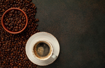 Obraz na płótnie Canvas Cup of tasty coffee and beans on a stone background. Top view with copy space for your text.