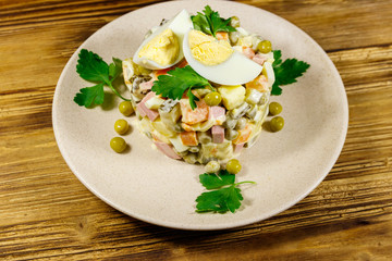 Traditional Russian festive salad Olivier on wooden table