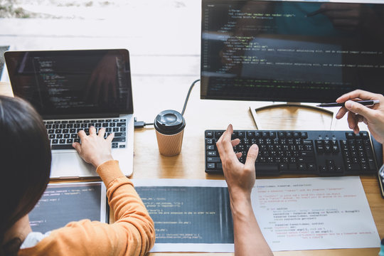 Programmers cooperating at Developing programming and website working in a software develop company office, writing codes and typing data code, Programming with HTML, PHP and javascript