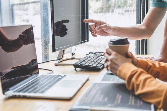 Two professional programmer cooperating and working on web site project in a software developing on desktop computer at company, codes and typing data code, Programming with HTML, PHP and javascript