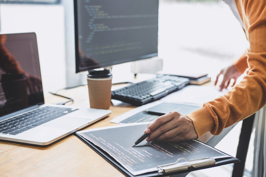 Young Professional programmer working at developing programming and website working in a software develop company office, writing codes and typing data code, Programming with HTML, PHP and javascript