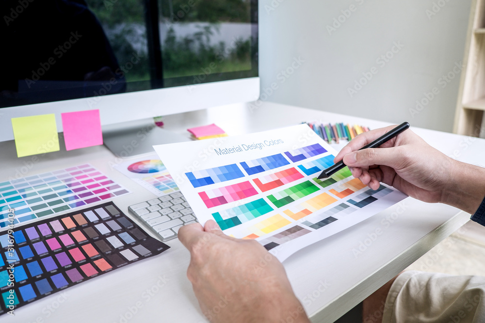 Aufkleber male creative graphic designer working on color selection and color swatches, drawing on graphics ta