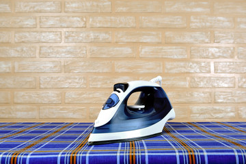 New modern electric steam iron on ironing board