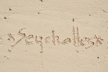 The word Seychelles written in the sand on Mahe beach