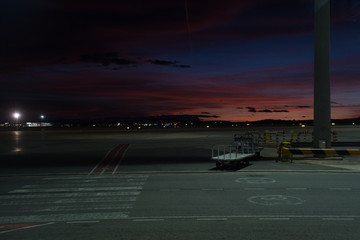 Nice sunset on the airport runway. Cargo car in the picture.