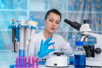 Fototapeta premium Young woman in chemical lab Young woman in chemical lab. cience professional pipetting solution into the glass cuvette.