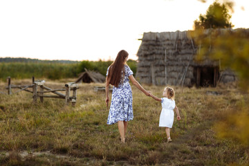 mom with daughter having fun together outdoor by the old house in village