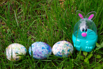 Easter egg bunny in green grass with speckled eggs and copy space