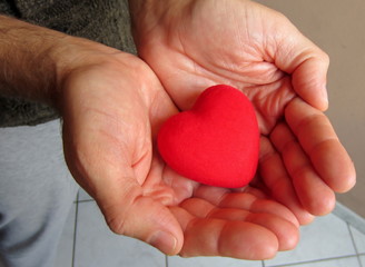 Heart in hands. Man's hands holding and giving heart to csomeone. Saint Valentines's Day gift and card concept.