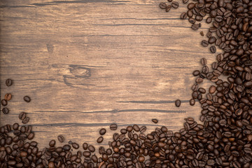 Coffee beans on wood background.