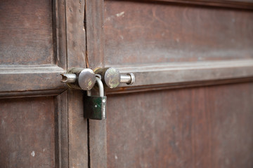 selective focus of traditional wooden door and rusty lock master key at asian temple.