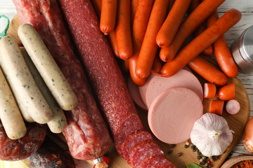 Different sausages and spices on wooden background, close up