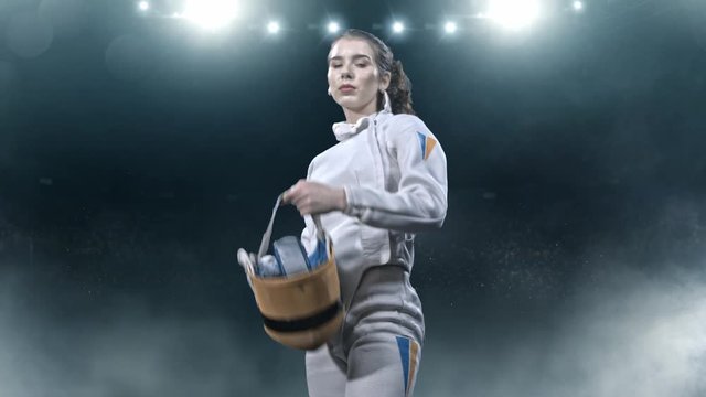 Two fencing athletes fight on professional sports arena.