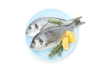 Plate with Dorado fishes, lemon and rosemary isolated on white background