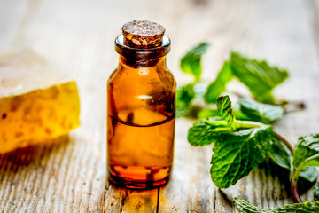 organic cosmetics with herbal extracts of mint on wooden background
