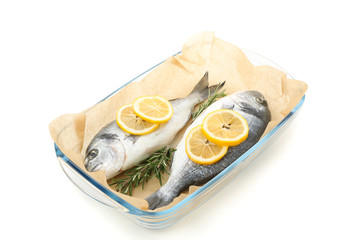 Baking tray with Dorado fishes, lemon and rosemary isolated on white background