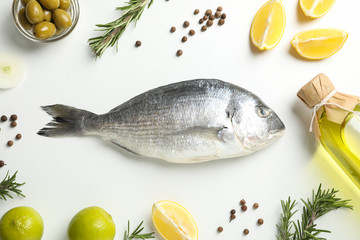 Fresh Dorado fish, spices and cooking ingredients on white background, top view