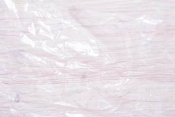 crumpled transparent polyethylene film on wooden background