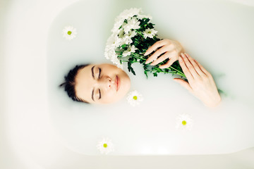 Pretty girl enjoying bath with flowers. Health And Beauty. Beautiful woman Bathing With Petals.